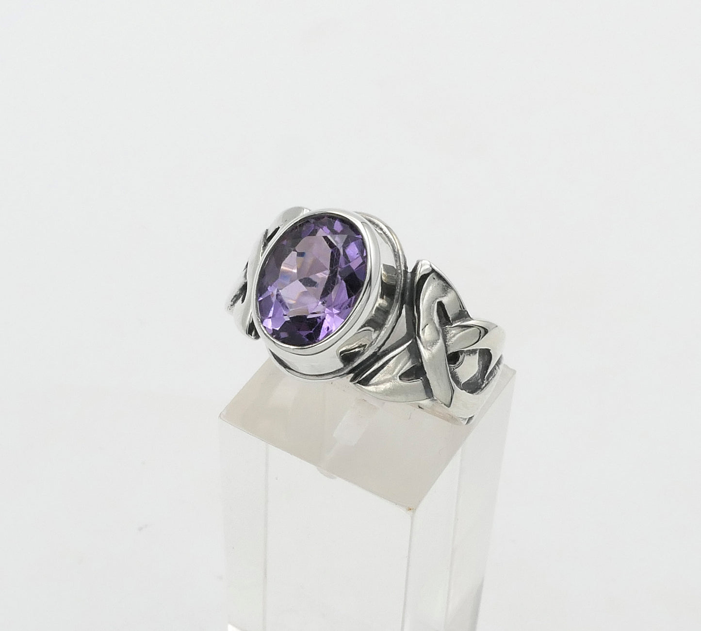 Silver ring with a purple gemstone on a white background