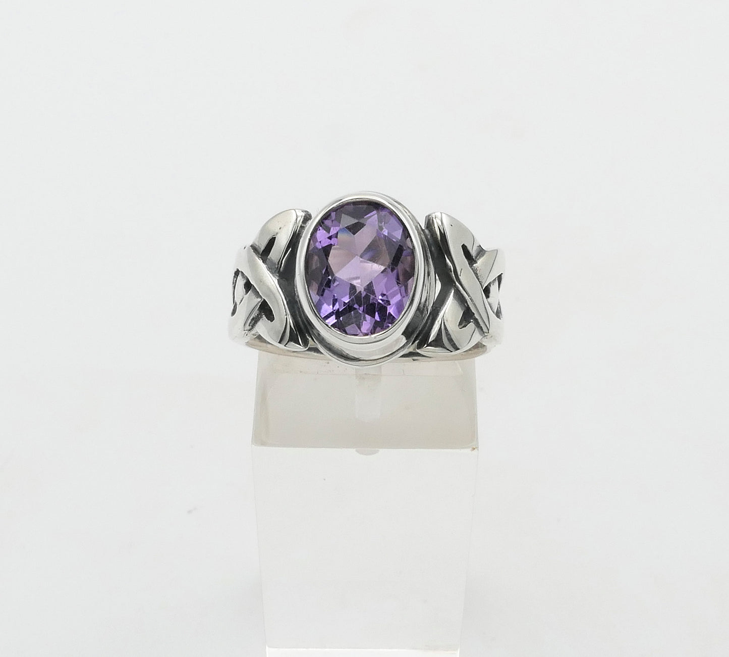 Silver ring with a purple gemstone on a white background