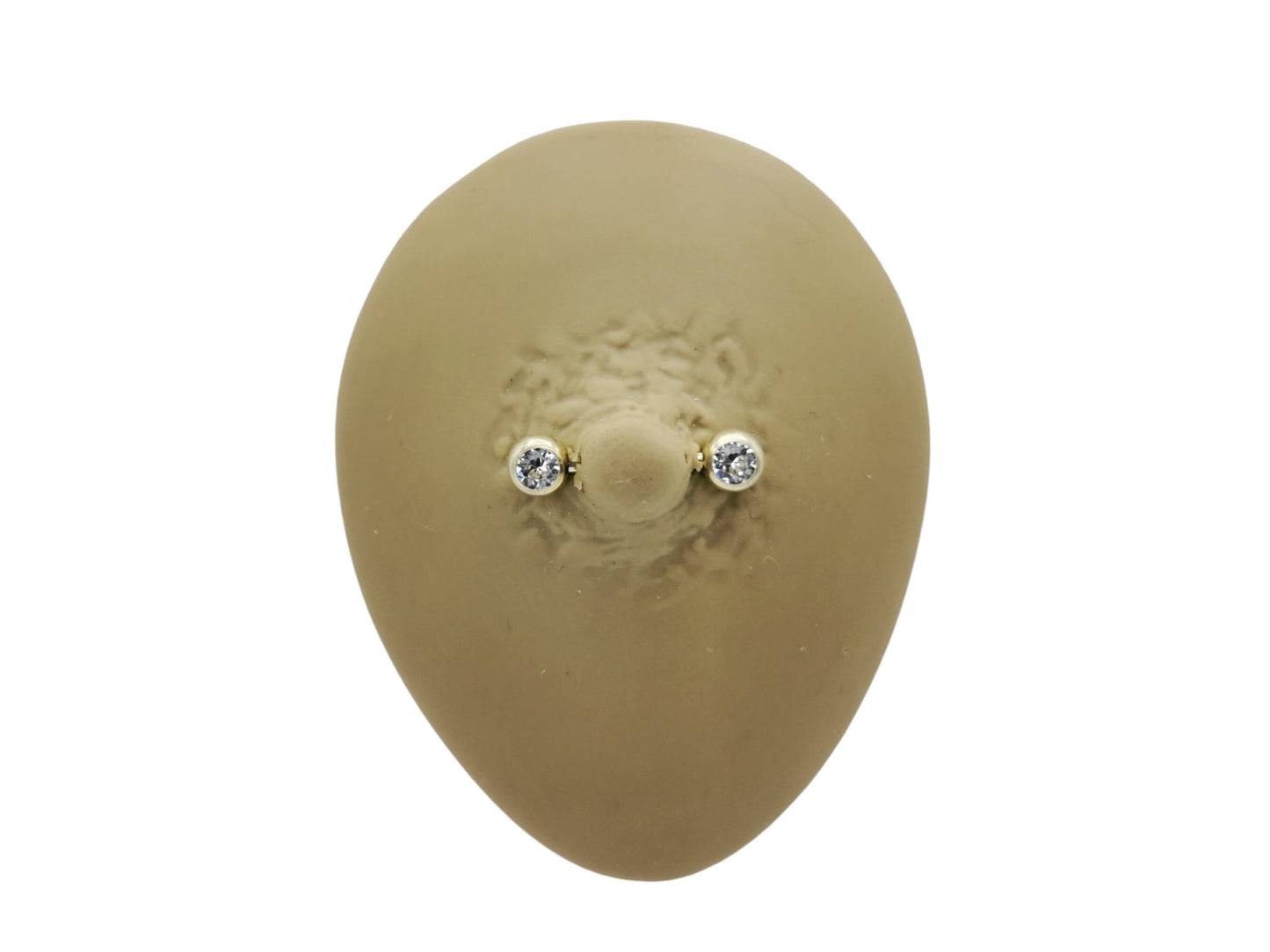 A gold-colored titanium barbell with a clear faceted crystal on the bezel, intended for nipple piercings.