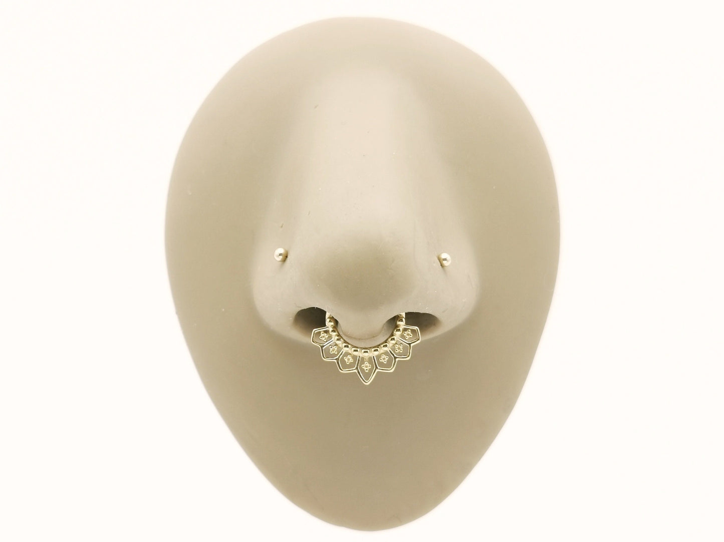 Gold surgcal steel mandala clicker ring in a mannequin nose