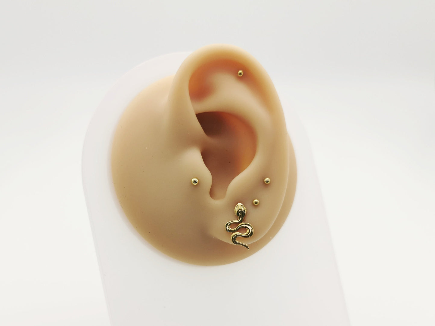 Gold titanium snake on an ear whith a white background