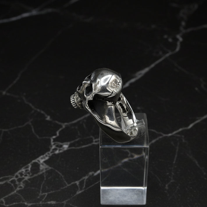 A Silver skull ring on a black background