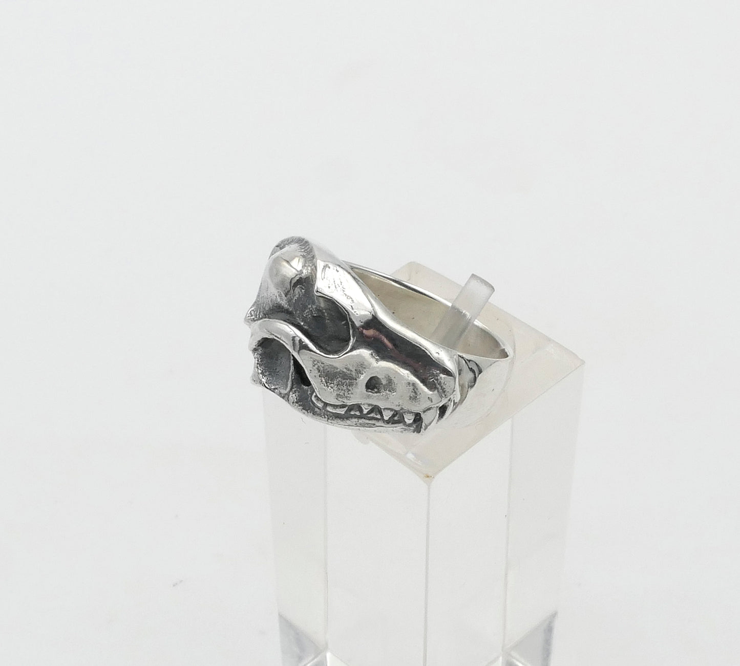 Silver fox ring with a unique design on a clear stand against a white background