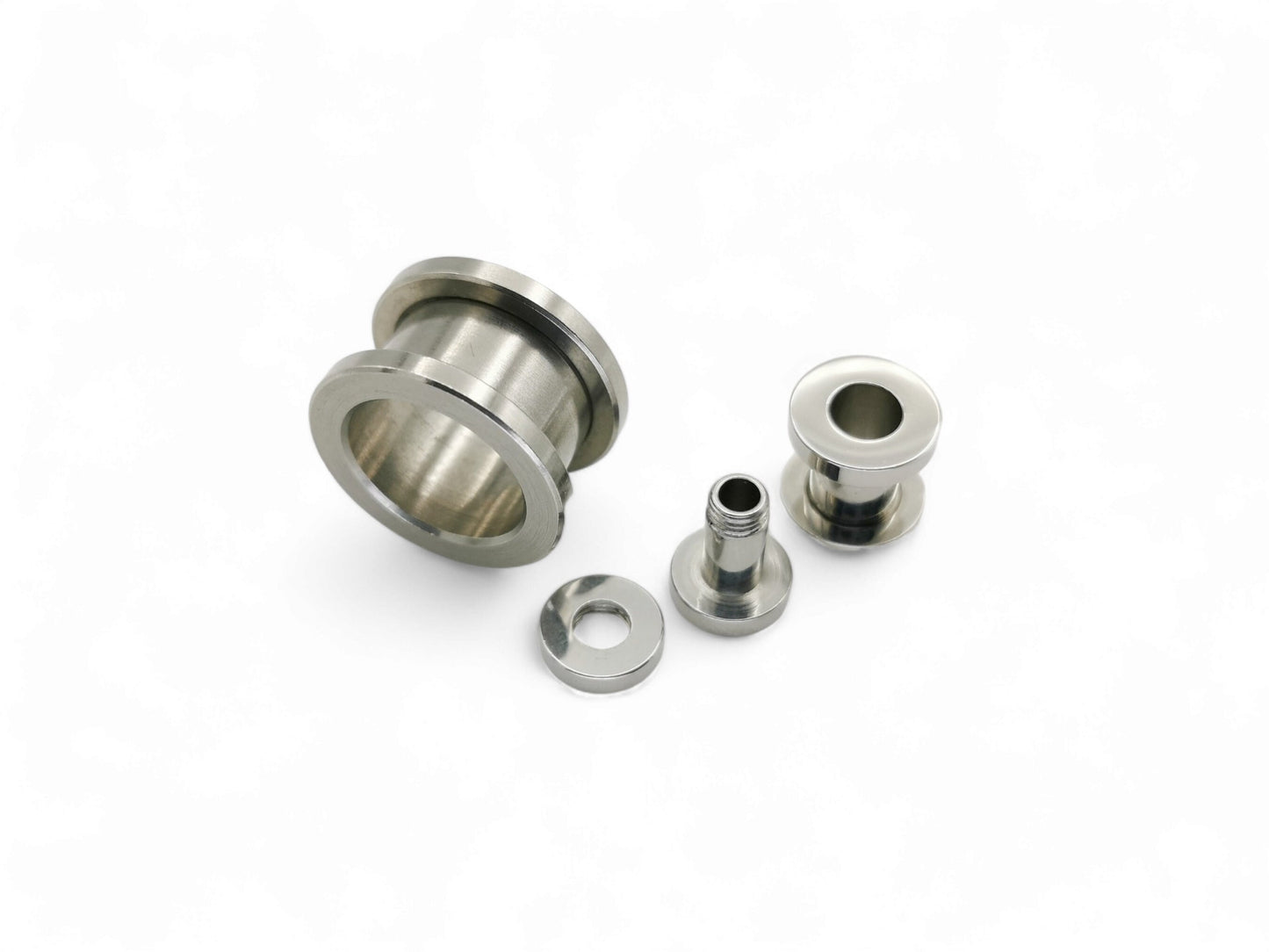 Surgical steel screw fit ear gauges on a white background
