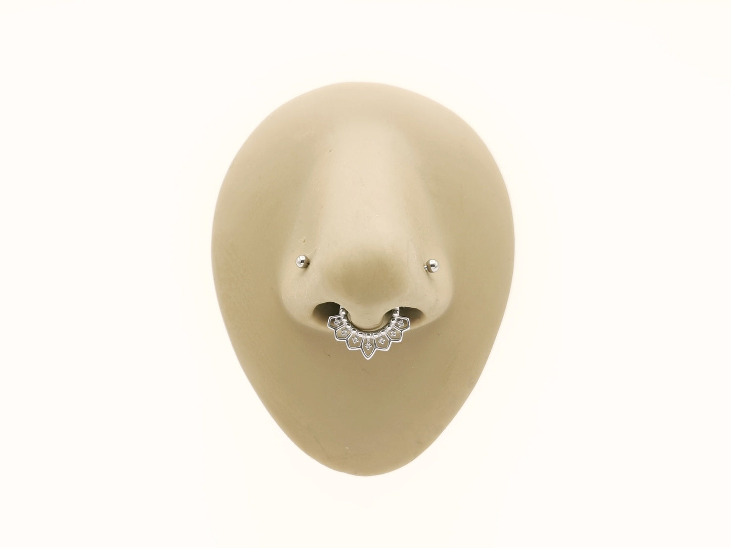 Surgical steel mandala clicker rings on a mannequins nose