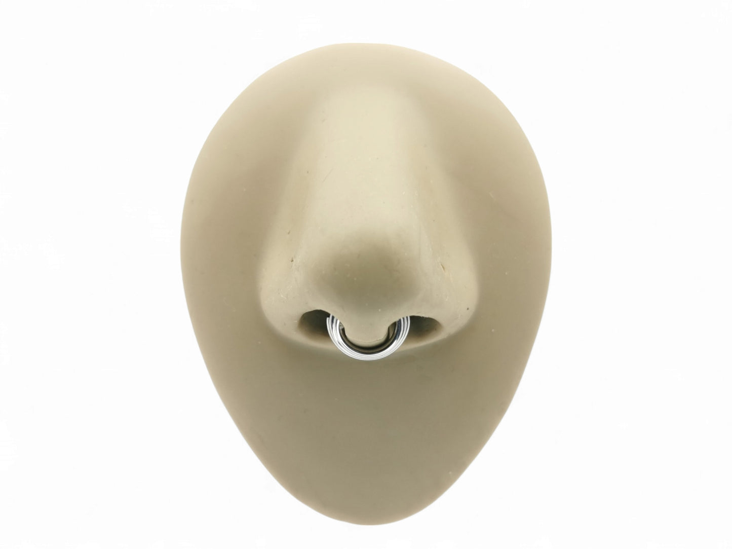 Titanium illusion septum ring on a mannequin nose