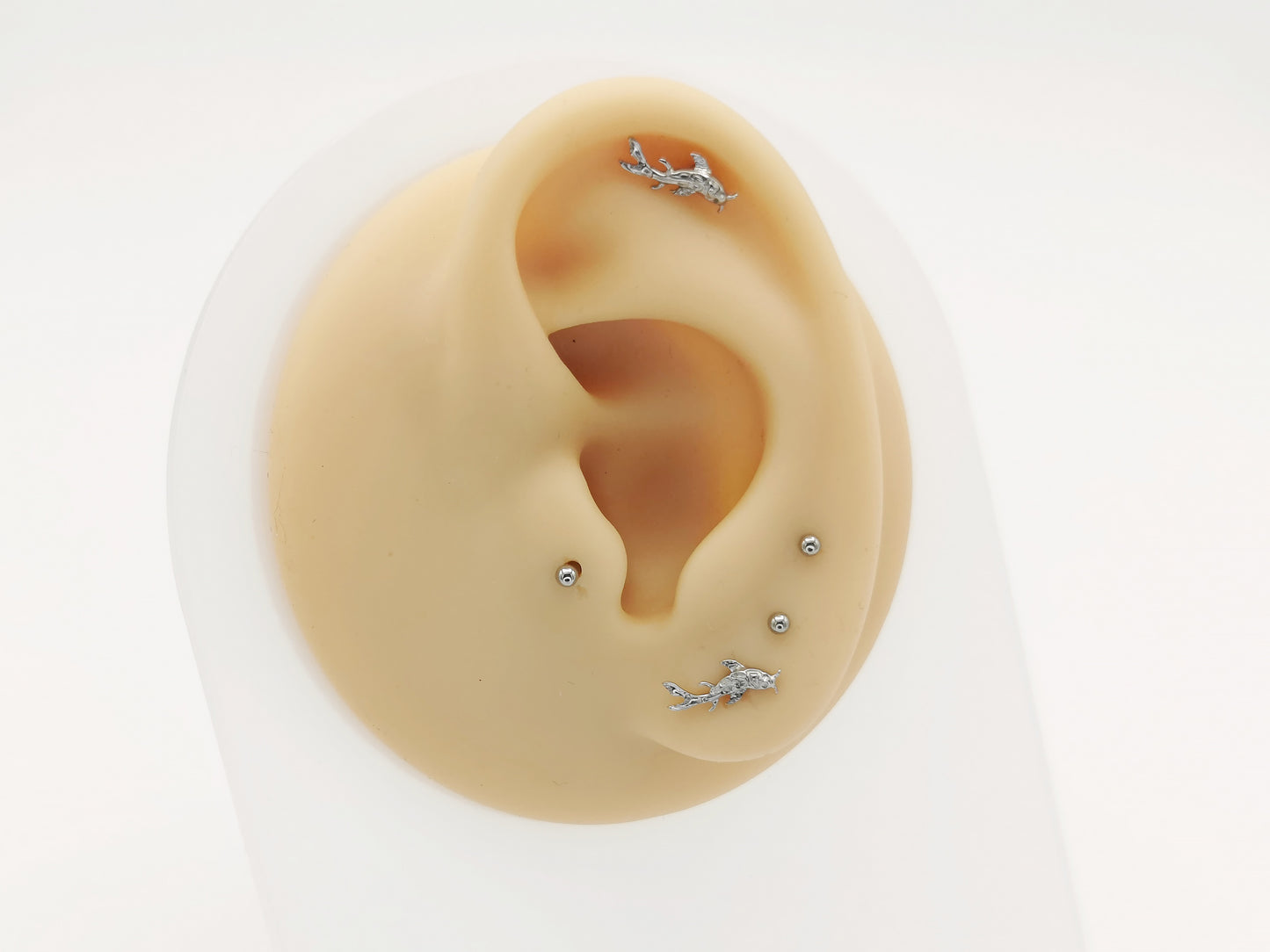 A pair of silver-colored titanium koi fish stud earrings with a mirror polish finish, showing both the front and side views.