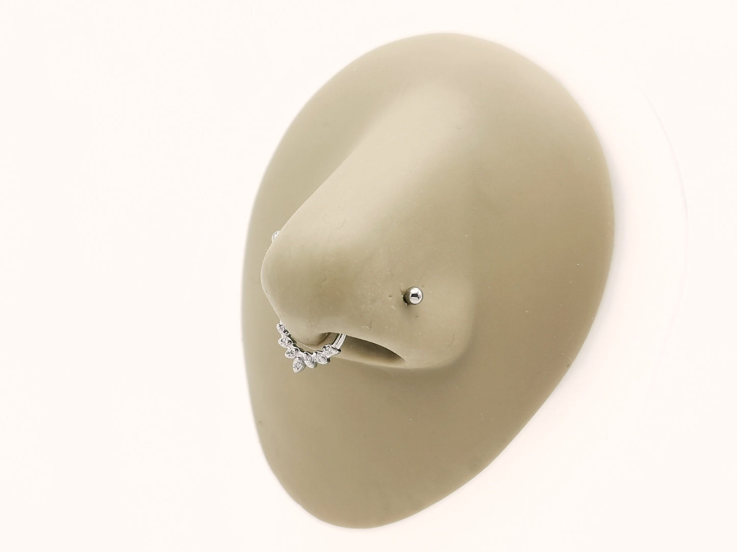 Titanium laurel wreath clicker on a mannequin nose