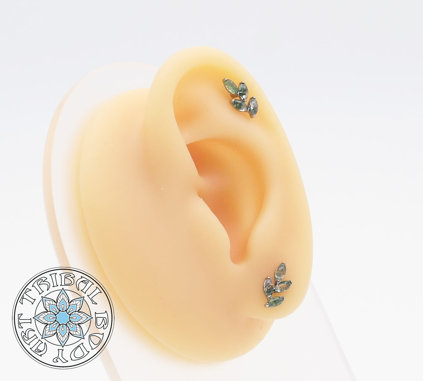 A pair of titanium moss agate leaf stud earrings with marquise-cut green stones set in a polished finish.