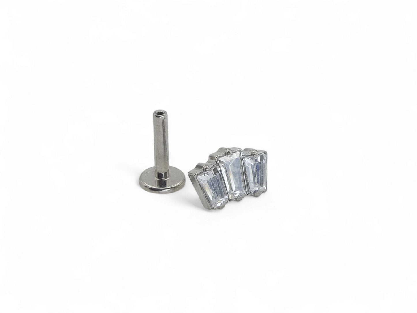 A single titanium push fit baguette cluster stud with multiple clear gemstones, against a white background.