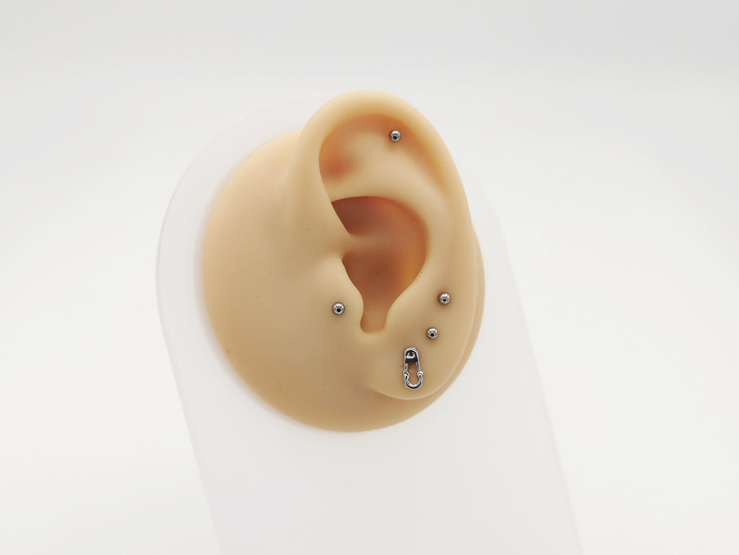 Titanium safety pin stud on a mannequin ear