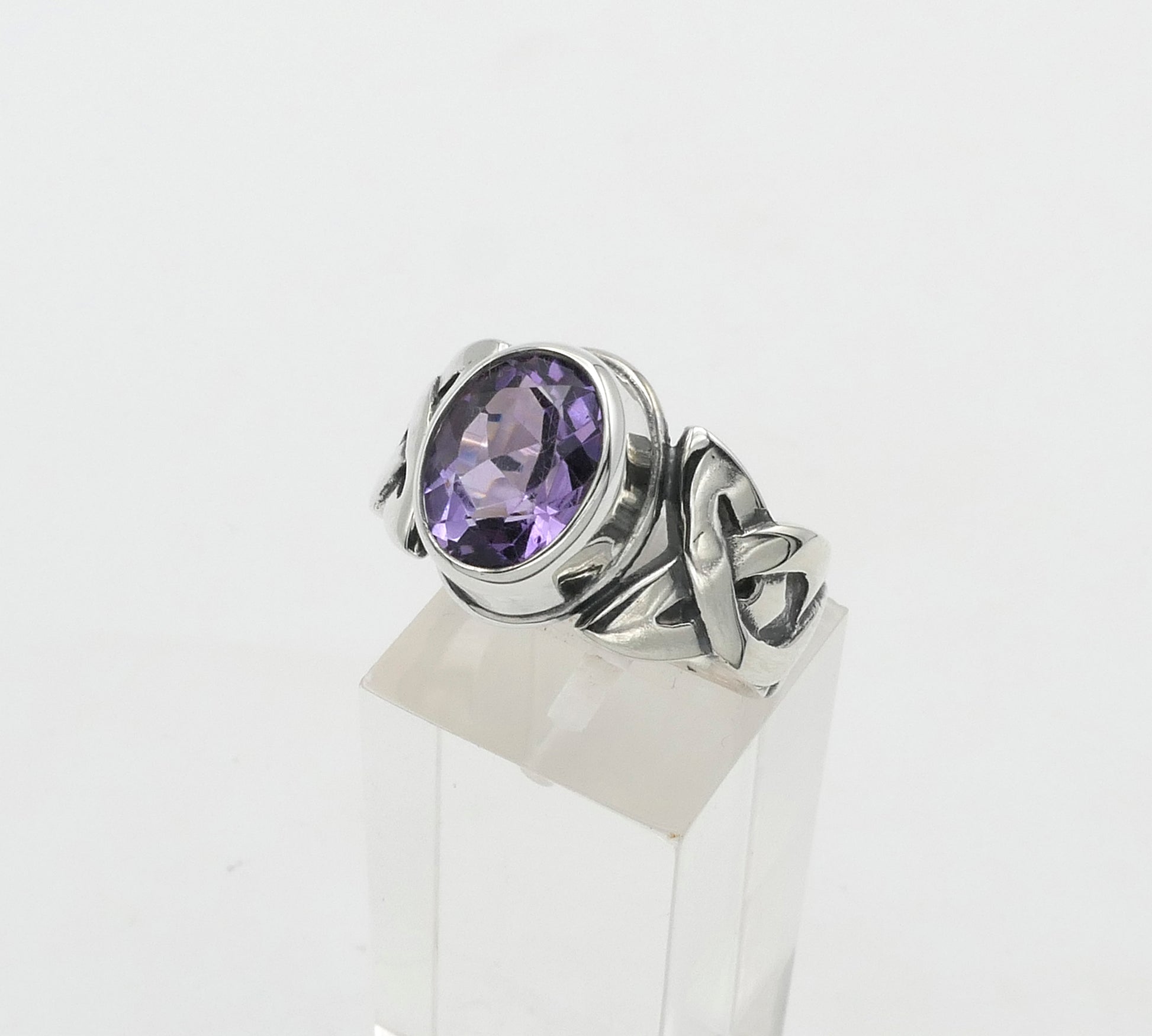 Silver ring with a purple gemstone on a white background