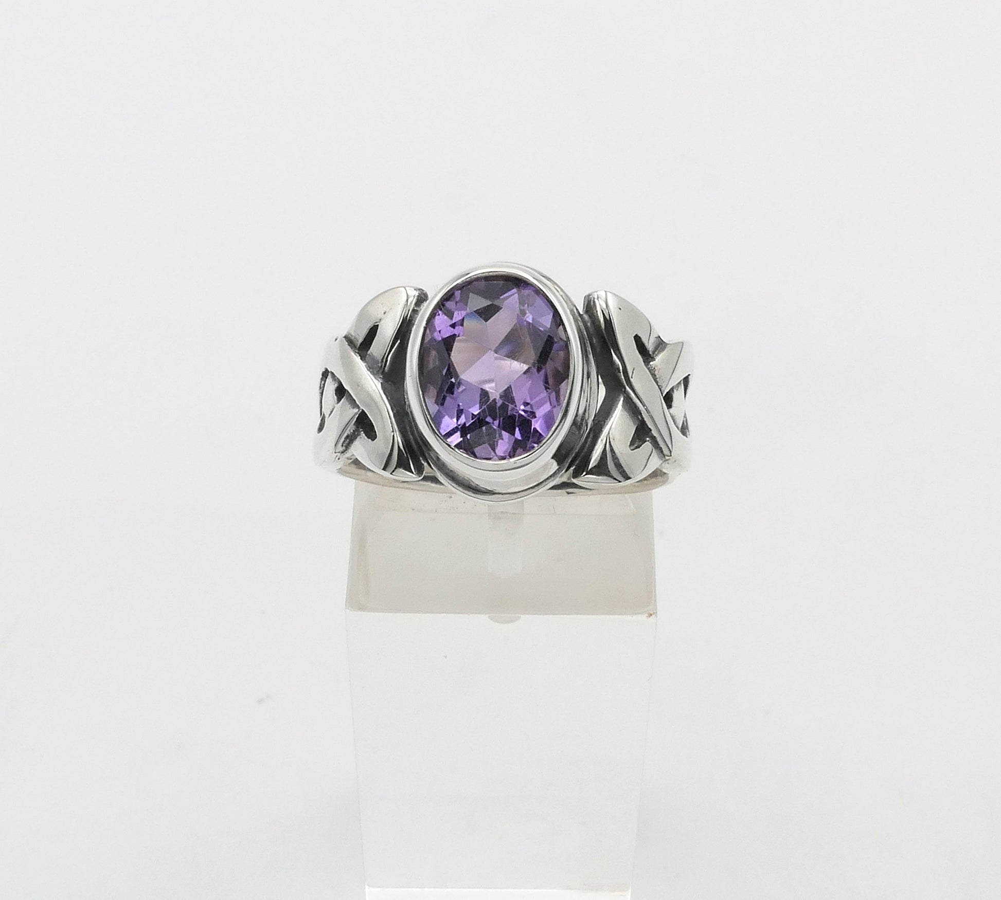 Silver ring with a purple gemstone on a white background
