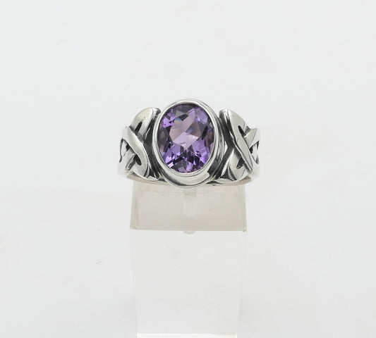 Silver ring with a purple gemstone on a white background