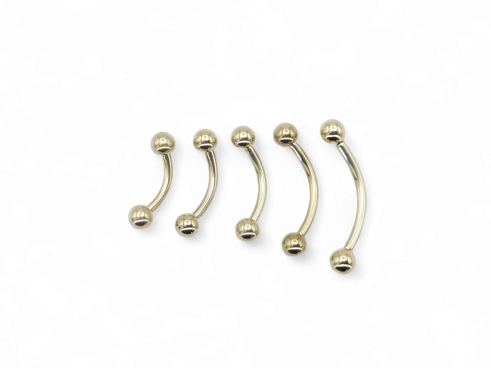 A black or gold titanium curved barbell, externally threaded for piercings, with a screw-fit ball.