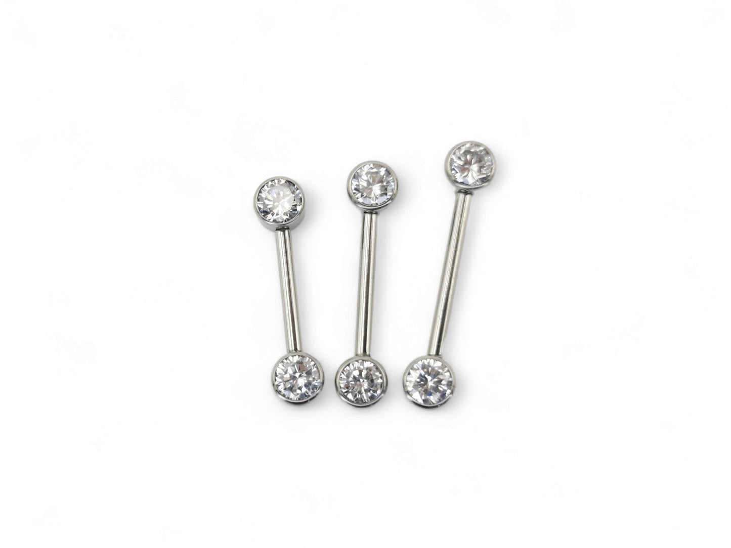 A set of three jewelled titanium barbells with clear faceted crystals, arranged in a row on a white background.