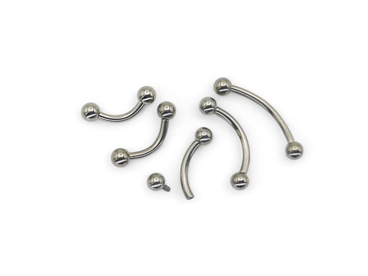 A collection of titanium curved barbells with screw fit balls, varying in length, on a white background.