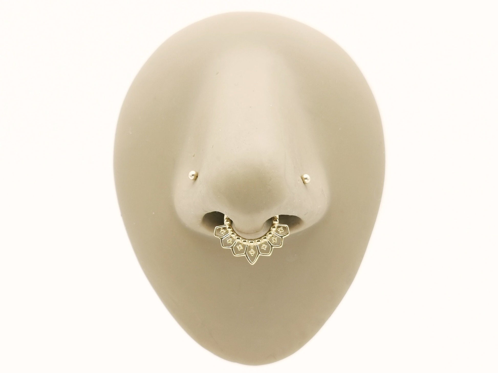 Gold surgcal steel mandala clicker ring in a mannequin nose