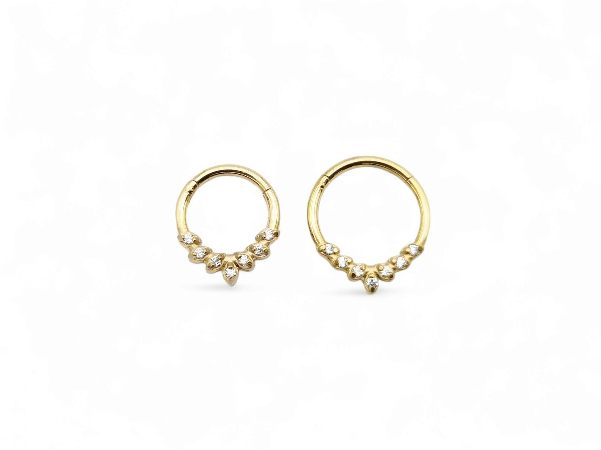 Gold surgical steel jewelled laurel clicker ring with cubic zirconias on a white background