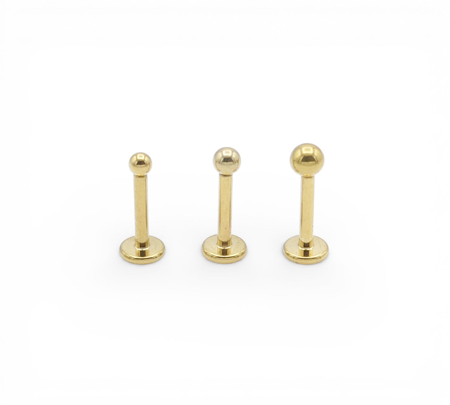 Three gold titanium studs on a white background