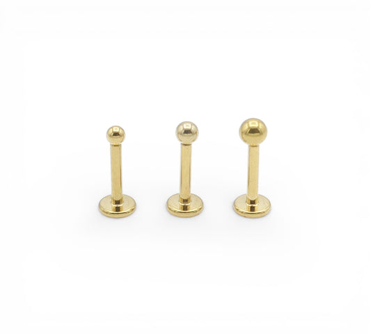 Three gold titanium studs on a white background
