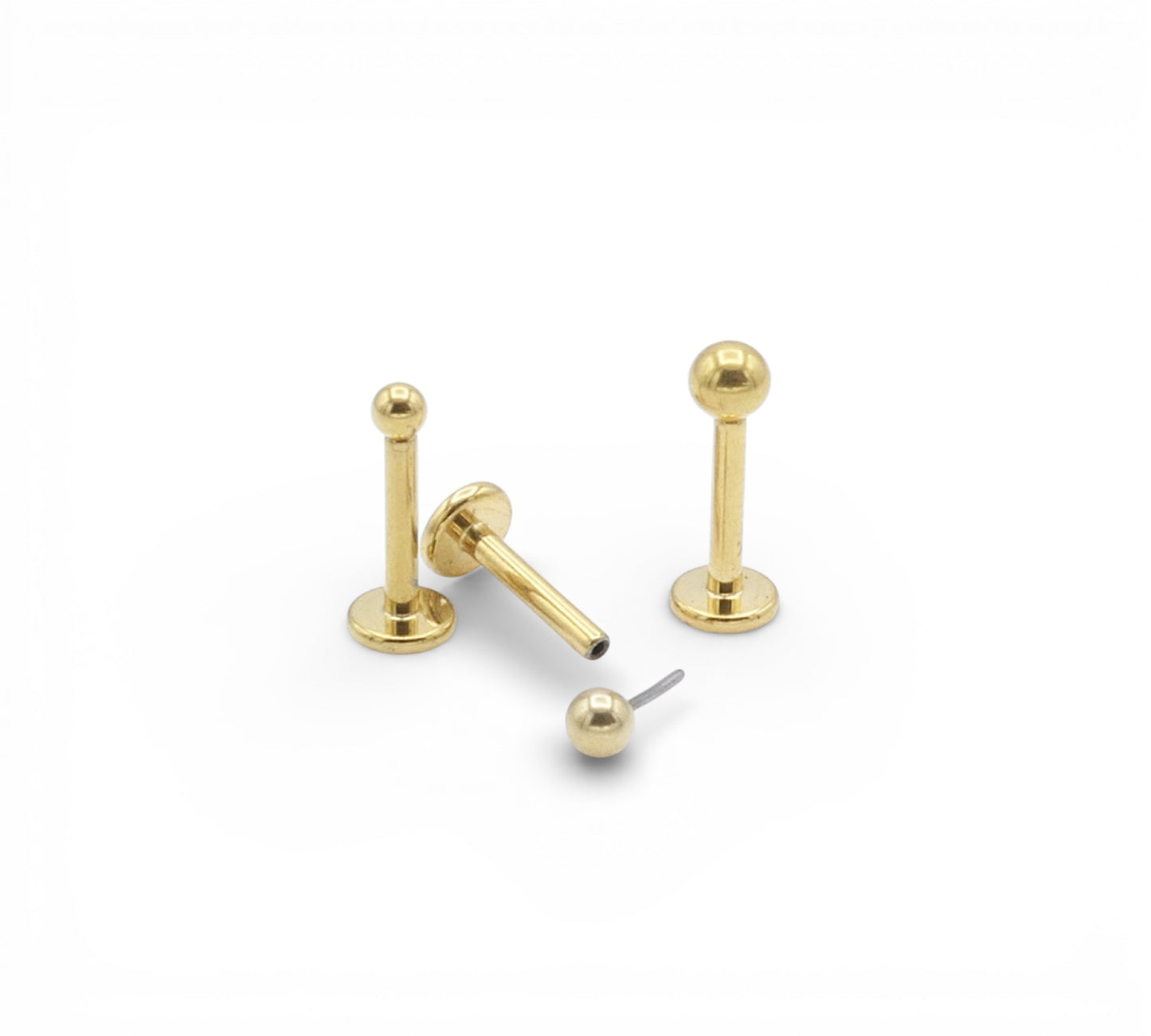 Three gold titanium studs on a white background