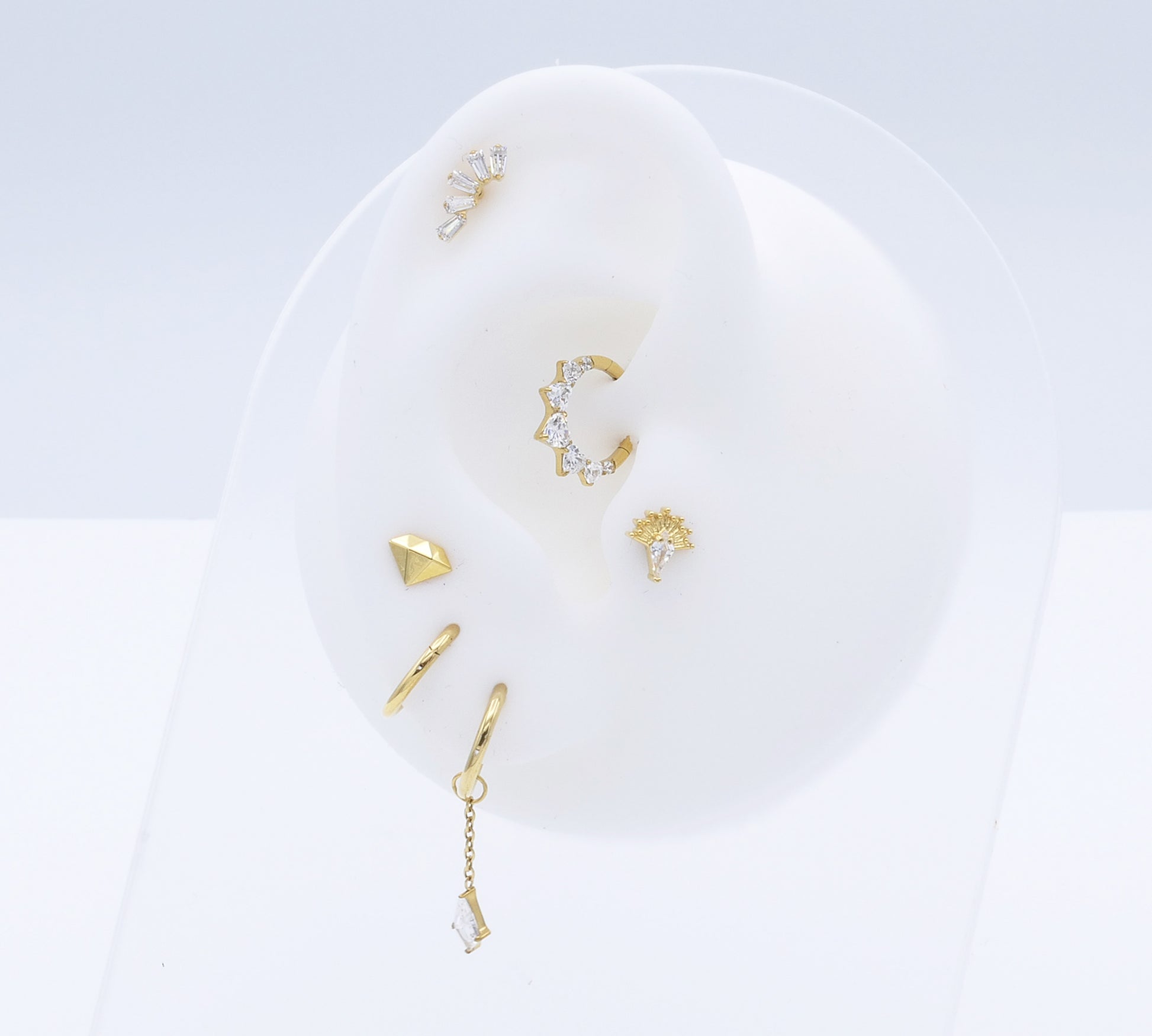 Set of gold earrings on a white dish