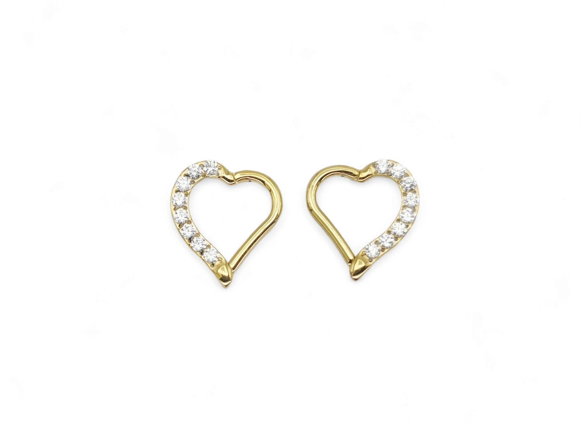 A pair of gold titanium jewelled heart clickers with PVD gold finish, designed for daith piercings.