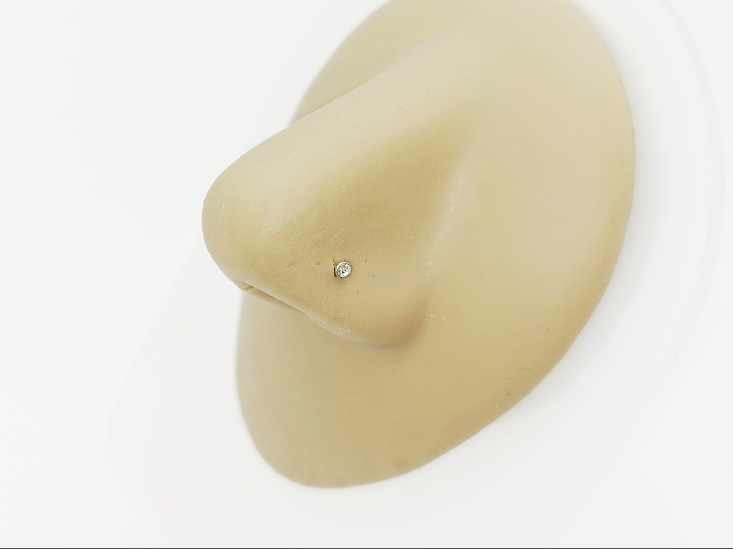 Gold titanium jewelled nose stud on a nose