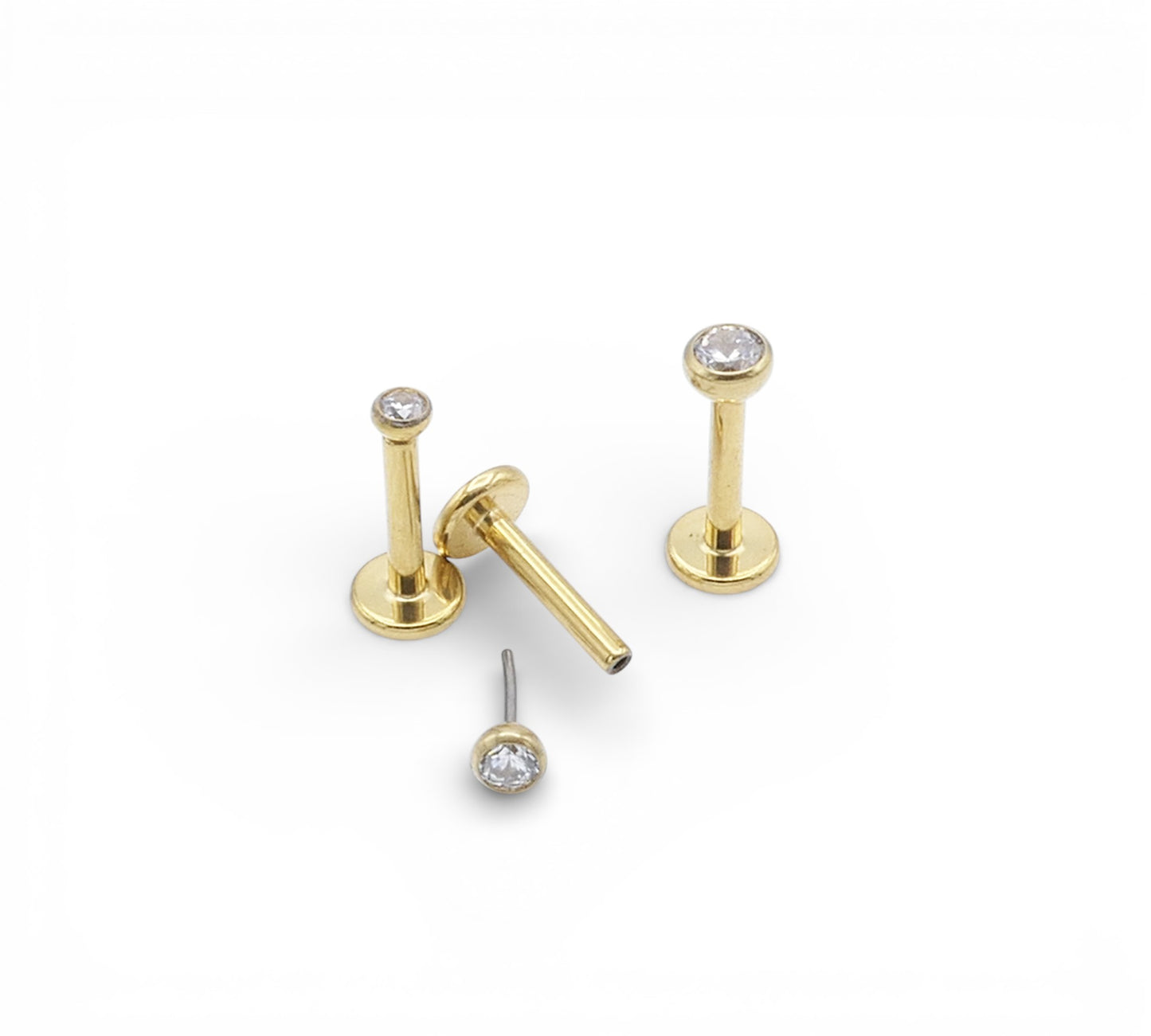 Gold  studs set with clear gemstones on a white background