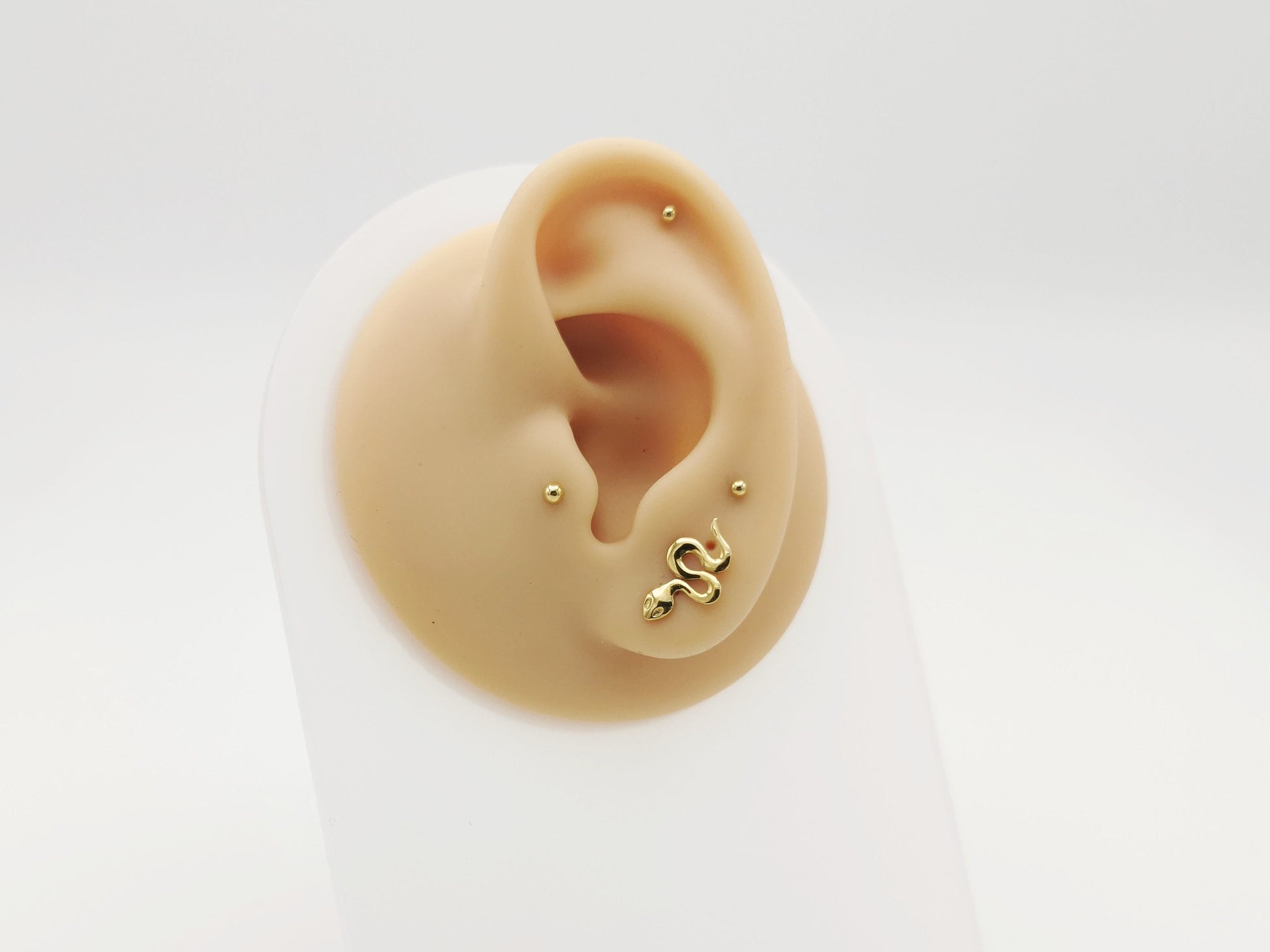 Gold_titanium_snake on an ear with a white background