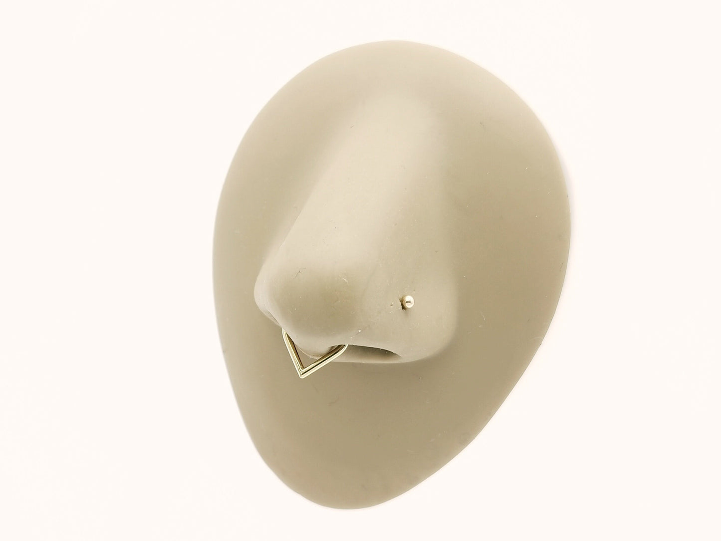 Gold titanium wishbone clicker on a nose