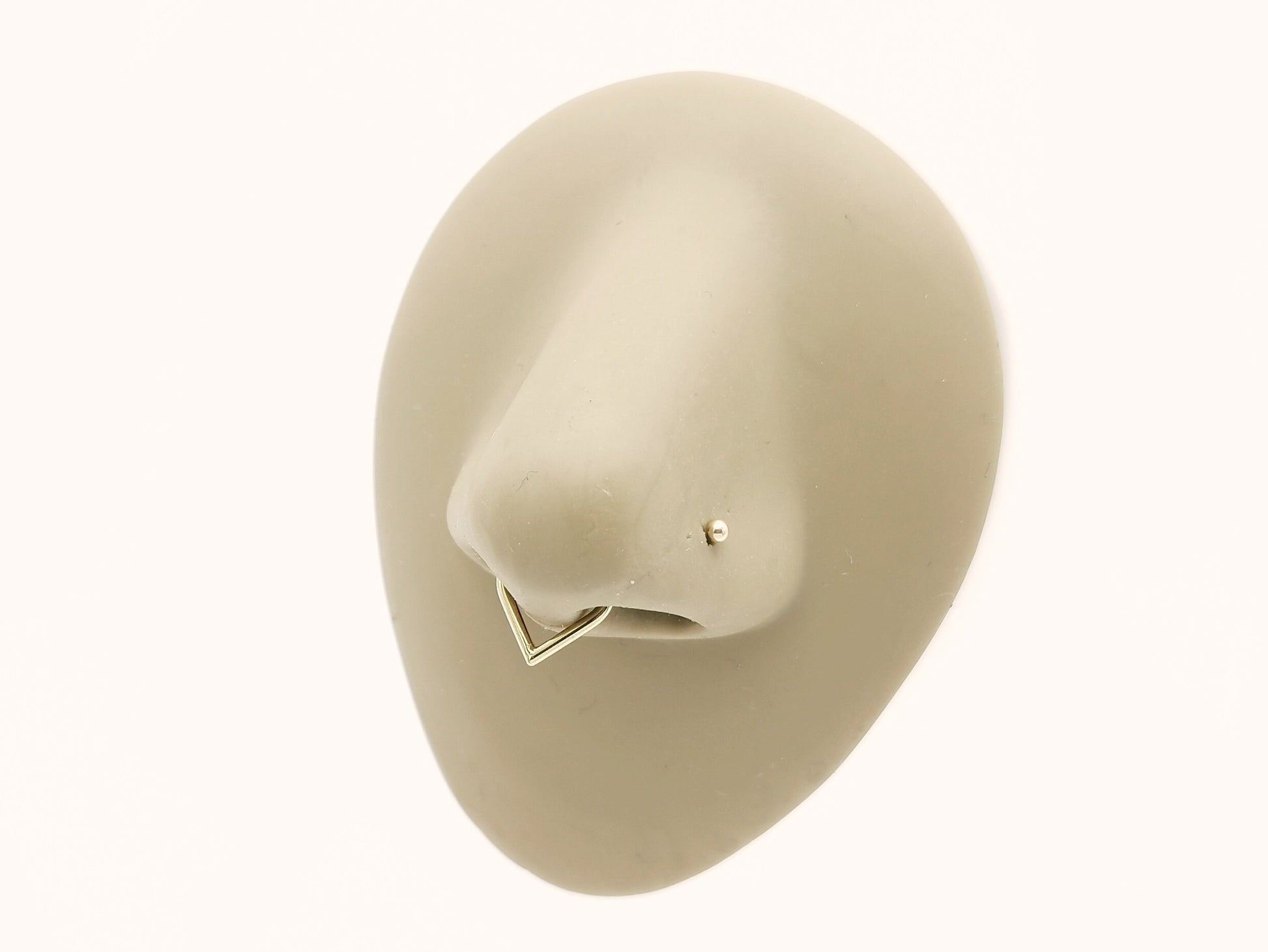 Gold titanium wishbone clicker on a nose