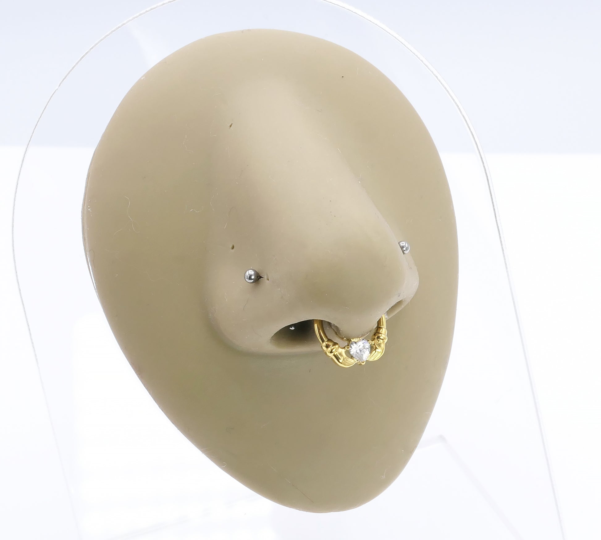 Jewelled Gold Titanium Claddagh Clicker ring on a nose model