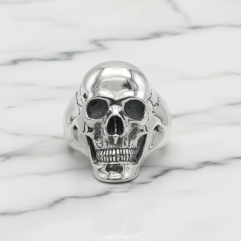 Silver skull-shaped ring on a white background