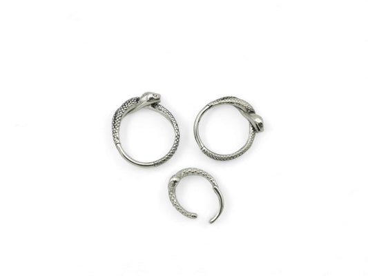 Three surgical steel serpent clicker rings on a white background
