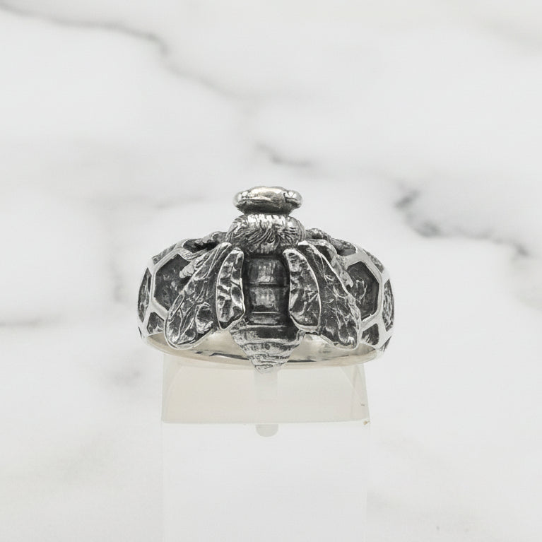 Silver ring with intricate design on a white background