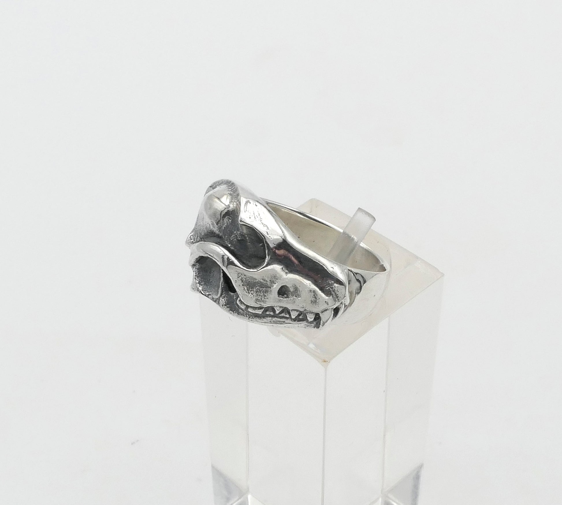 Silver fox ring with a unique design on a clear stand against a white background