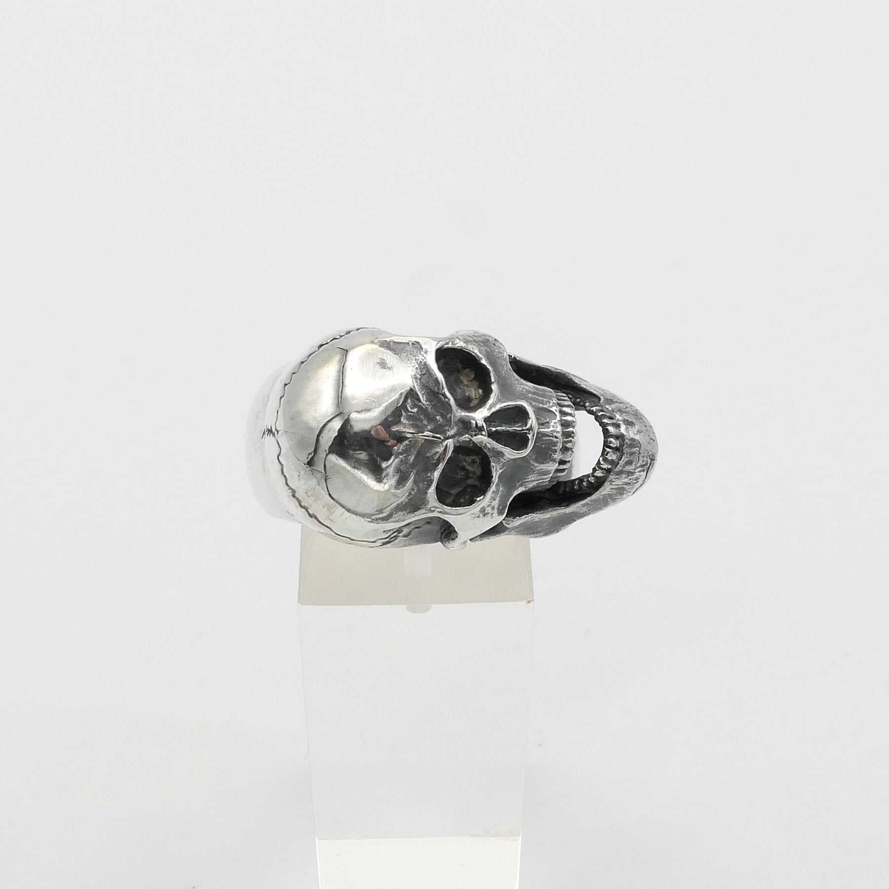 Silver skull-shaped ring on a white background