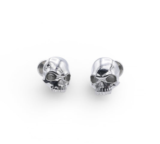 Pair of silver skull-shaped earrings on a white background