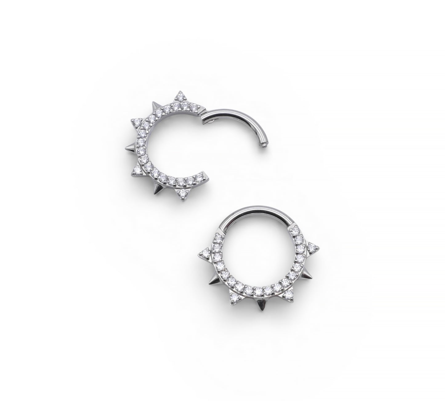 Jewelled and spiked titanium clicker rings on a white background