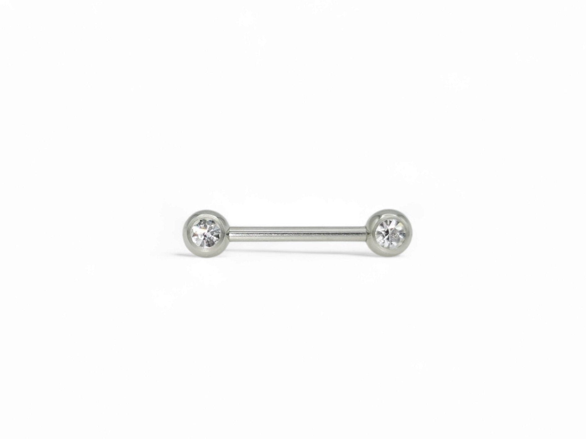 A set of three surgical steel barbells with jewelled ends, varying in length, on a white background.