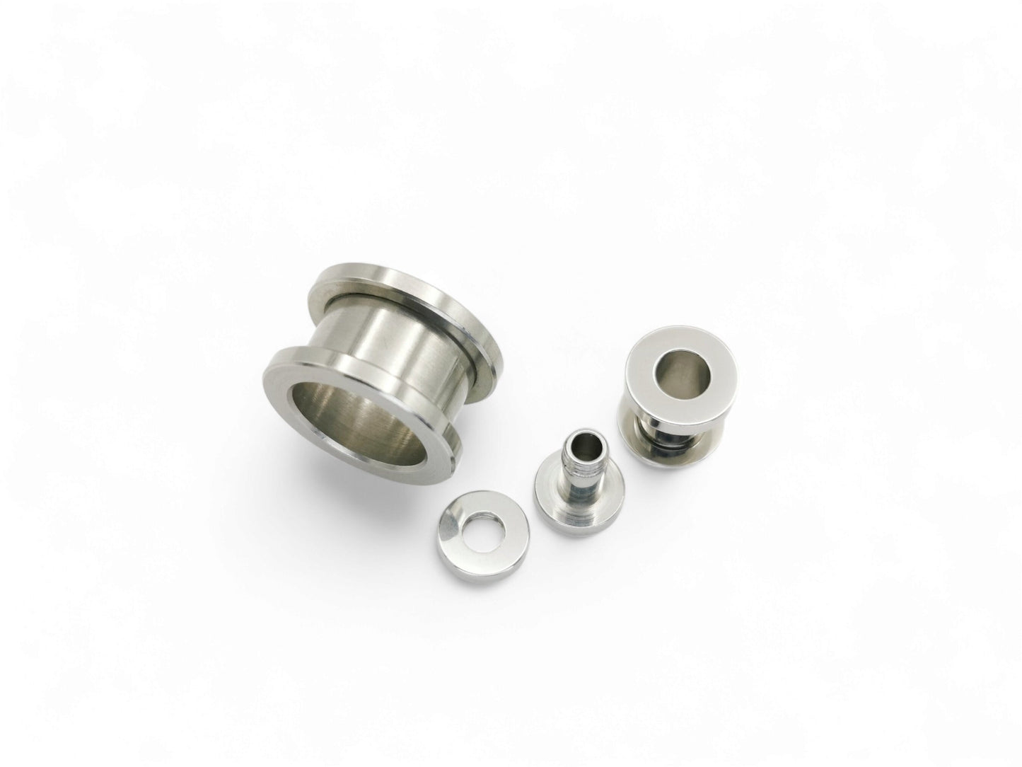Surgical steel screw fit ear gauges on a white background