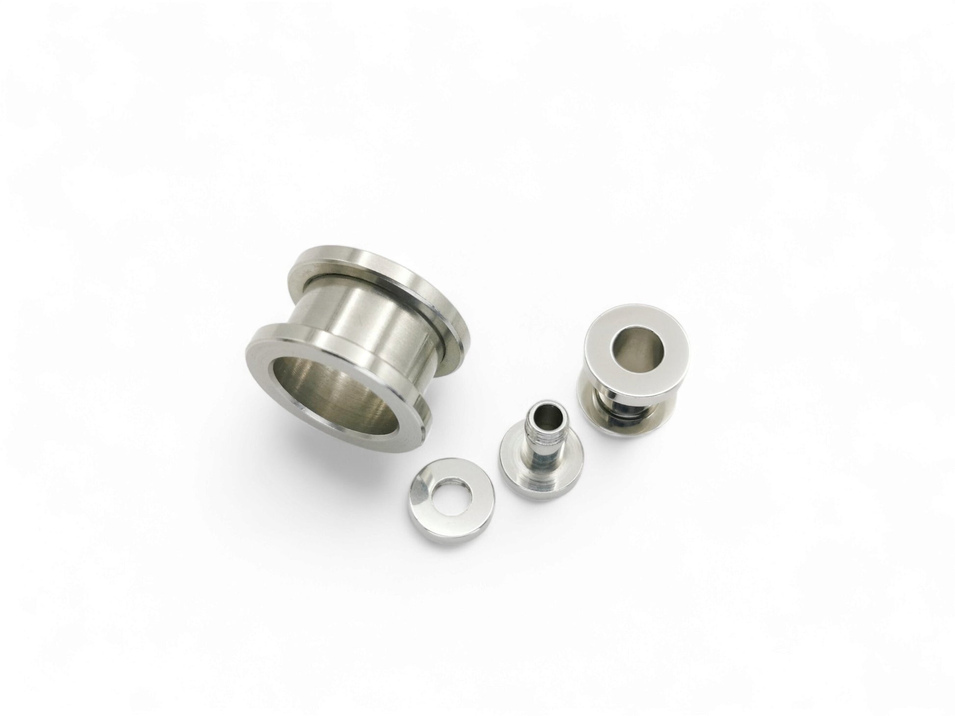 Surgical steel screw fit ear gauges on a white background