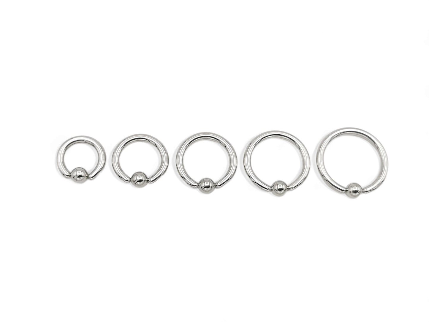 A set of five surgical steel BCRs with a ball closure design on a white background