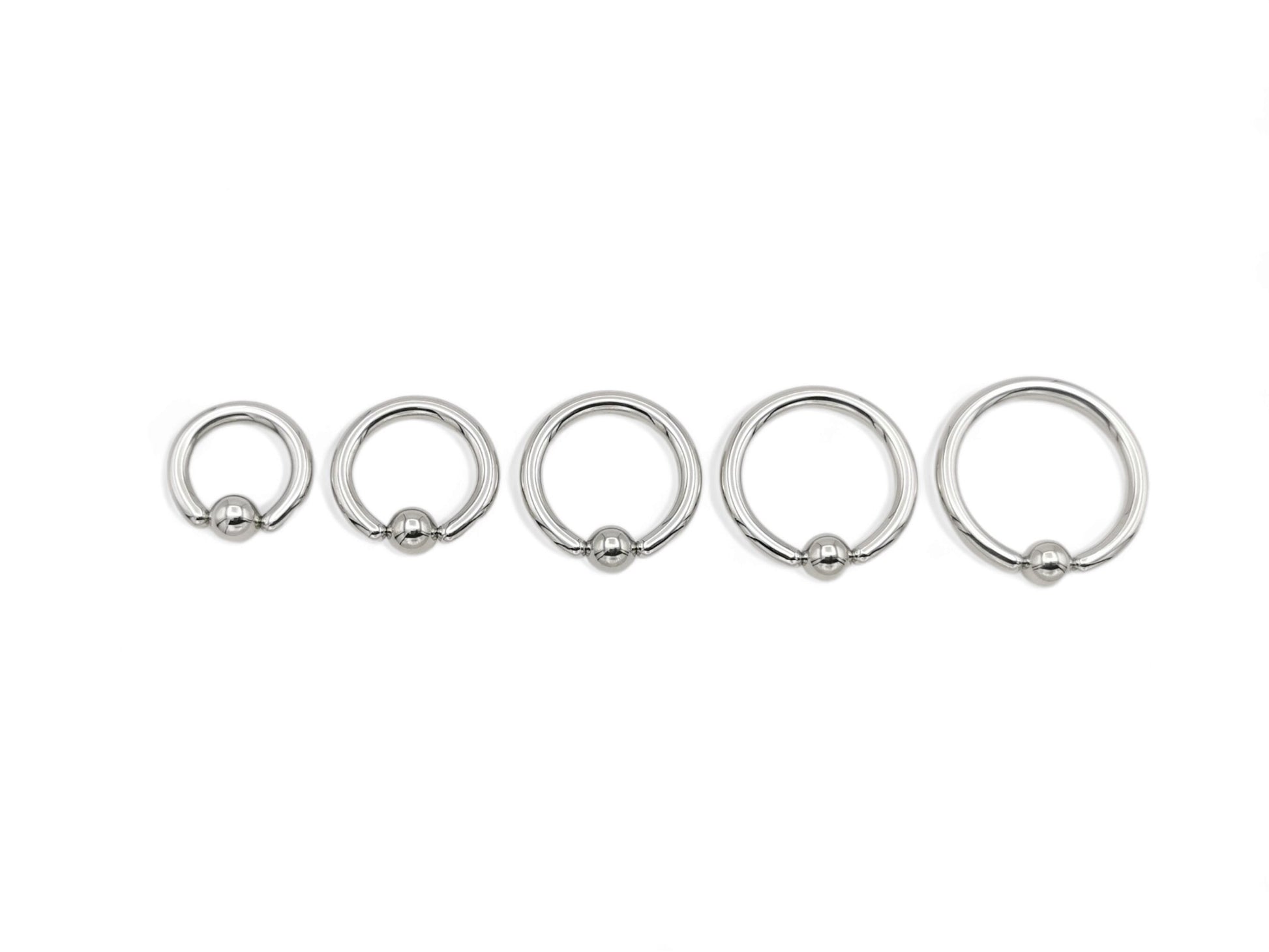 A set of five surgical steel BCRs with a ball closure design on a white background