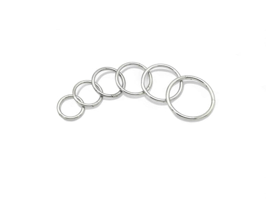 Surgical steel clicker rings on a white background