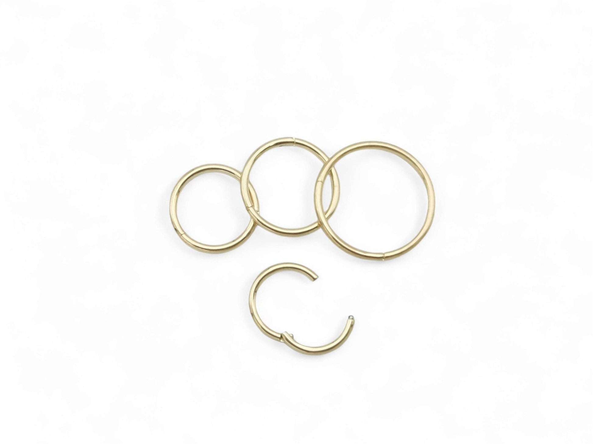 Four gold colour clicker rings on a white background