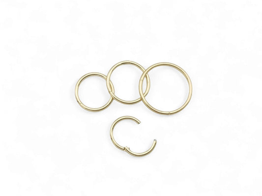 Four gold colour clicker rings on a white background