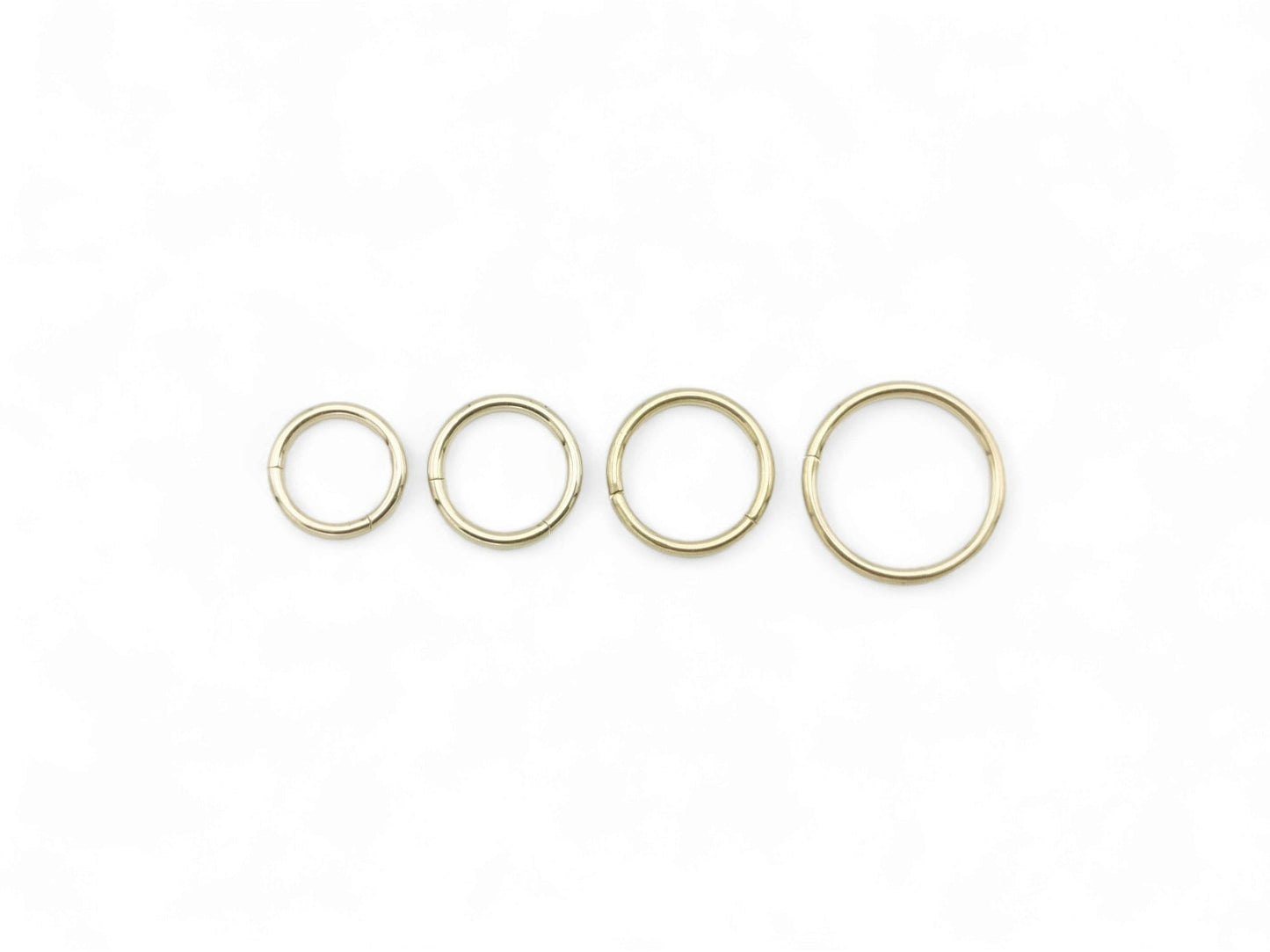 Four gold colour clicker rings on a white background